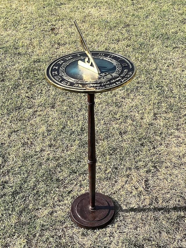 This unique turquoise sundial adds a touch of color and tradition to a lush garden, providing a peaceful retreat and a reminder of time's gentle flow