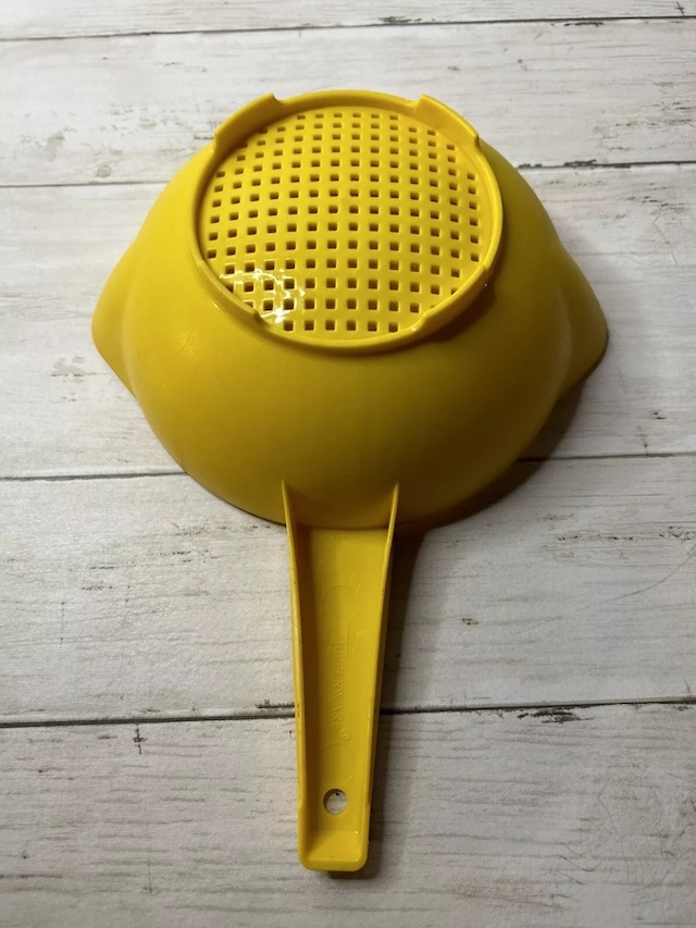 The back of the vintage plastic strainer, with its practical design, making it easy to handle during all sorts of kitchen tasks