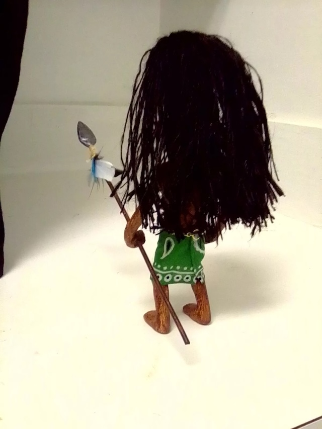 The Zuni Fetish Doll as seen from behind, showcasing its traditional tribal skirt and spear, perfectly crafted to look fearsome from every angle