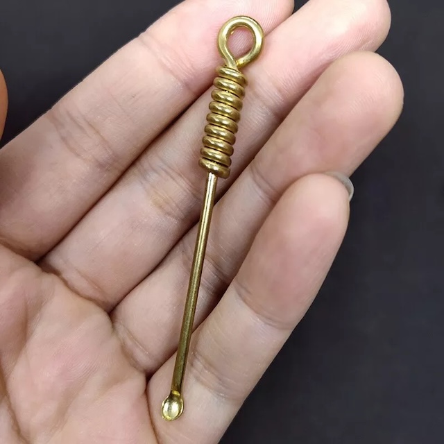 A vintage earwax remover with a spring-like handle, designed for easy grip and effective use, highlighting clever old-world engineering