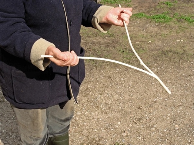 With a steady grip, this dowser demonstrates a classic method of water divination, using a Y-shaped stick in the search for underground water supplies