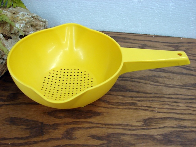 A kitchen essential that brought color and practicality to homes in the past, this bright yellow plastic strainer evokes memories of simpler times