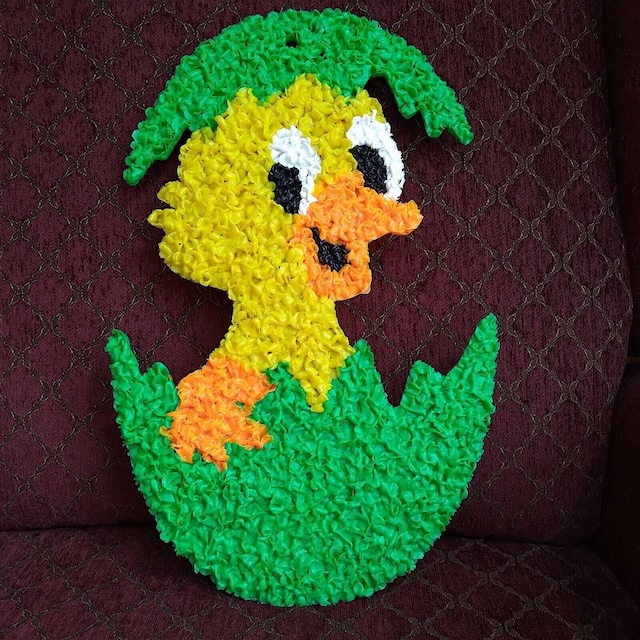 A fun and colorful Easter chick hatching out of its egg, made from nostalgic melted plastic popcorn decorations