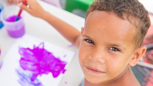 Painting outside the lines: a young artist deep in thought while creating a masterpiece