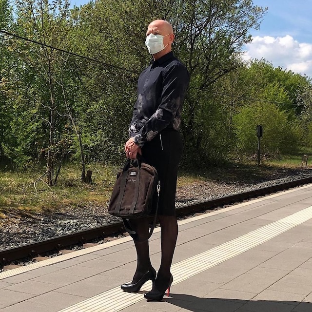 Embracing elegance: Mark Bryan combines a tailored suit with a skirt, heels, and a polished briefcase