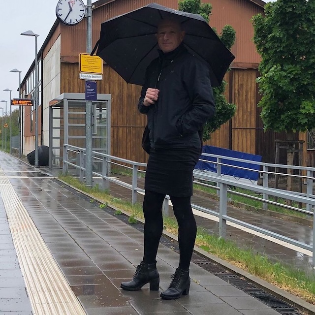 Embracing the rain: A rainy day look with a black skirt, high heels, and a stylish umbrella