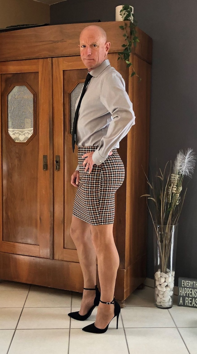 Boldly standing out in the crowd with a checkered skirt and black heels, this man confidently challenges gender stereotypes in his professional attire