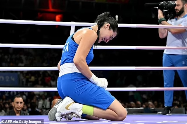 Angela Carini kneels in the ring, overwhelmed with emotion, after deciding to end the match