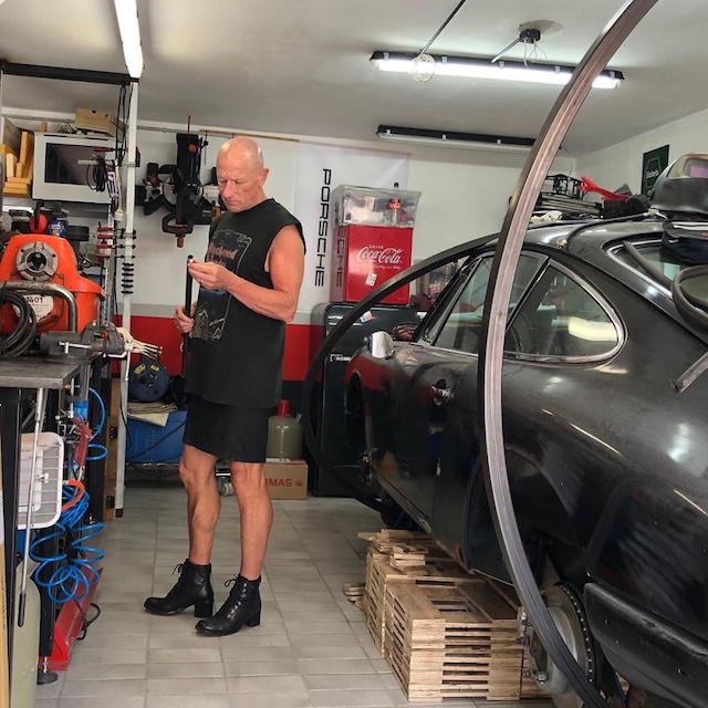 Mark Bryan works in his garage wearing a skirt and high-heeled boots, proving that fashion doesn’t stop at the workplace