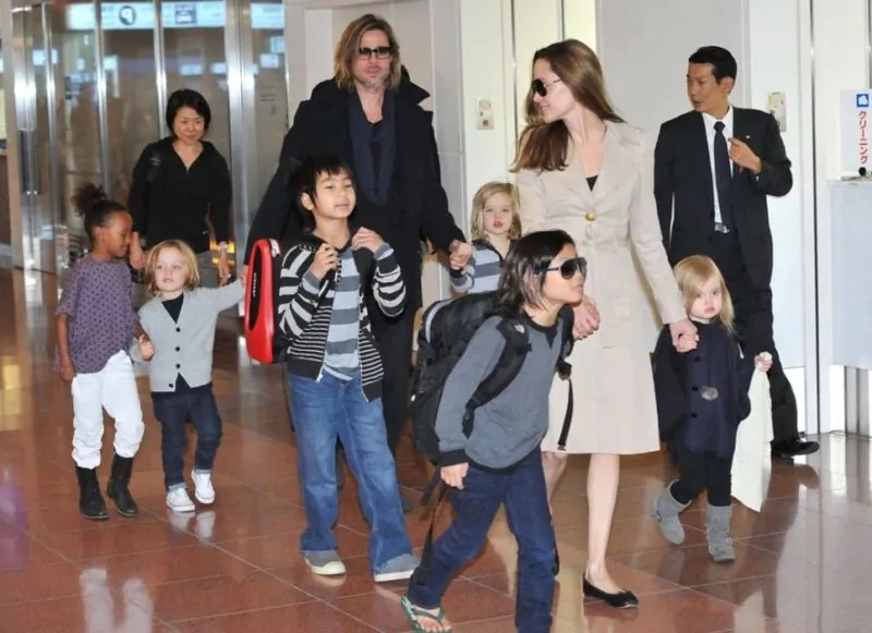 The Jolie-Pitt family captured during a busy airport moment, highlighting the dynamic of their large, vibrant family life