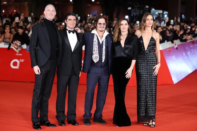 Depp receives the prestigious Lifetime Achievement Award at the Rome Film Festival, holding the award with a grateful smile. A significant moment in his career, recognized by fellow actor Riccardo Scamarcio