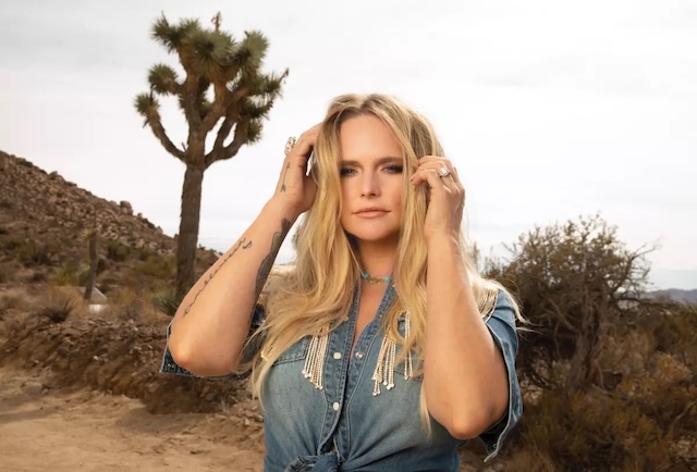 Miranda Lambert poses against a rugged desert backdrop, embodying the raw, authentic spirit of her country roots with a denim look that complements the natural landscape