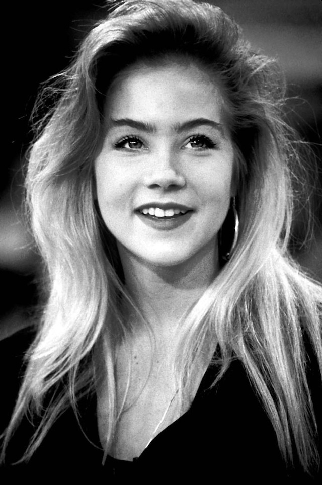 A young and radiant Christina Applegate smiles in black and white, showcasing the youthful energy that made her a beloved TV star