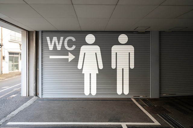 Bold signage leading to public restrooms with the iconic 'WC' symbol