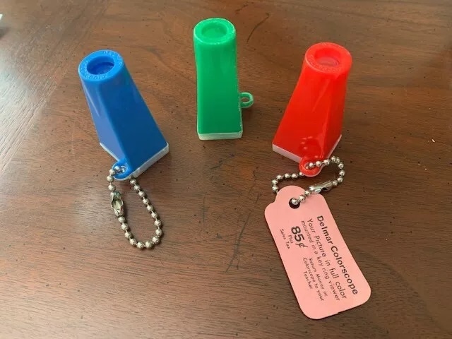 A colorful collection of Vintage Delmar Colorscope picture viewer keychains in red, green, and blue—each a portal to cherished childhood moments