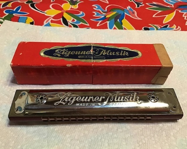 Nestled alongside its original packaging, this vintage harmonica embodies the spirit of musical creativity from a bygone era