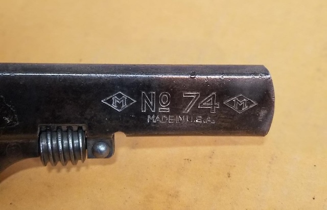 Close-up of the No. 74 marking on a vintage adjustable wrench. A small tool with a big role in history, proving its durability and design