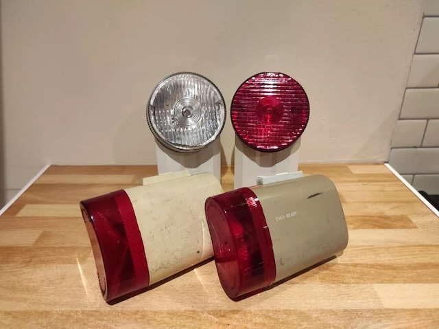 A collection of vintage bicycle lights, both front and rear, highlighting their durable casing and classic aesthetic