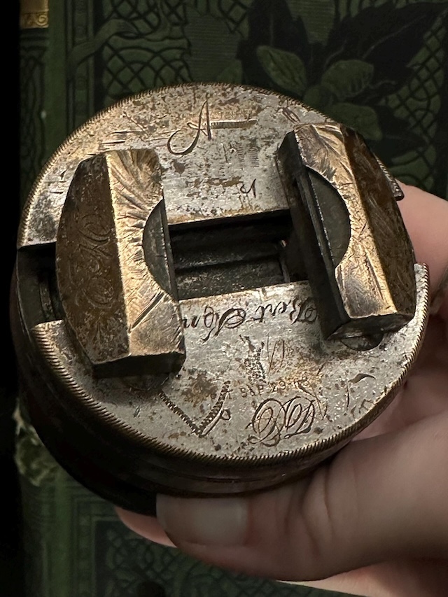 This close-up showcases the detailed engravings on the metal parts of the Antique Wooden Rotating Workbench, highlighting the craftsmanship of its time