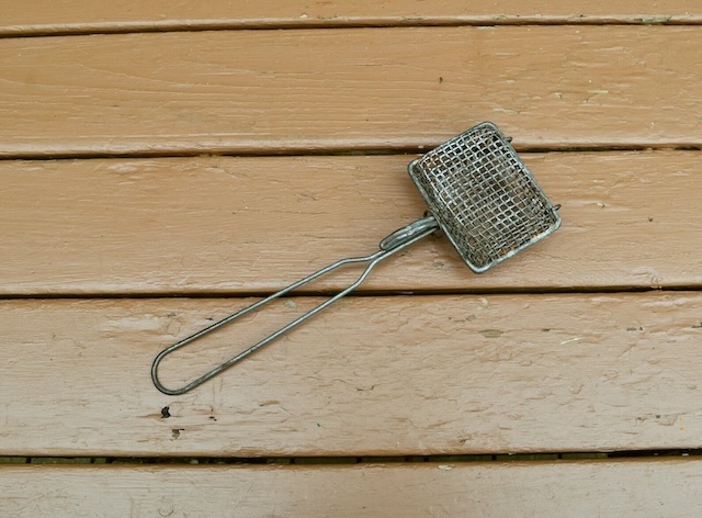 Laid against a wooden background, this vintage Wire Basket Soap Saver tells the story of simpler times when every sliver of soap was reused