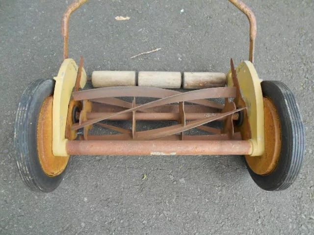 A close-up view of the cutting mechanism reveals the precision and engineering behind this vintage reel mower, which once graced many front lawns