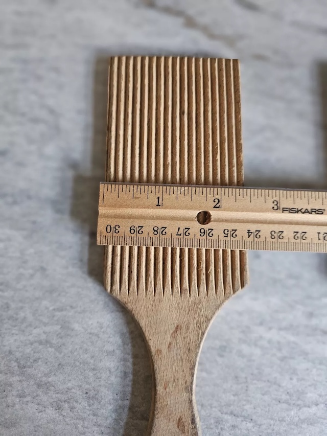 A single butter paddle measured with a ruler, showcasing its precise dimensions and functional design. A perfect example of a tool tailored to purpose and durability