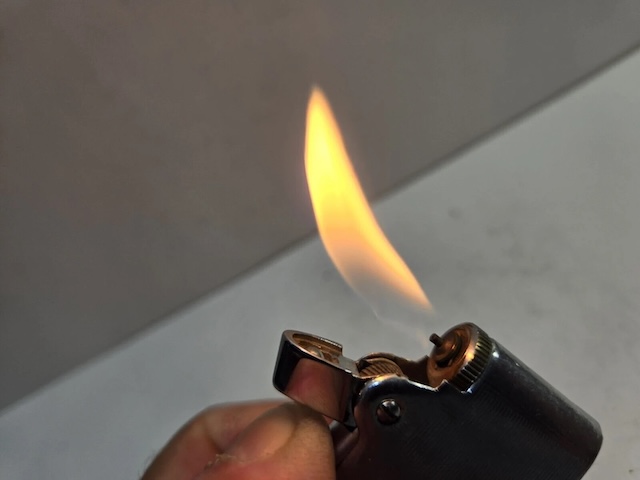 Igniting the flame with a simple flick—the Vintage Ronson Varaflame lighter in action, a nostalgic symbol of reliability and sophistication