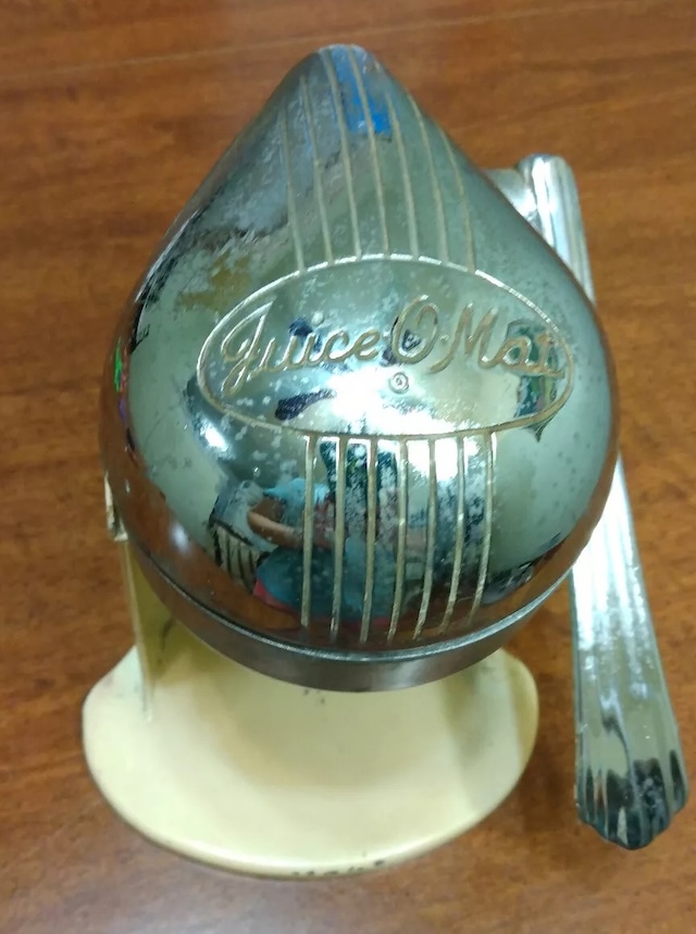 Close-up of the shiny metal dome featuring the 'Juice O Mat' branding, a nostalgic reminder of quality and craftsmanship