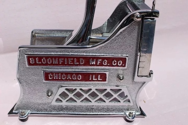 A detailed side profile of the vintage Bloomfield vegetable cutter or slicer, proudly displaying its maker's mark and fine craftsmanship from Chicago, Illinois