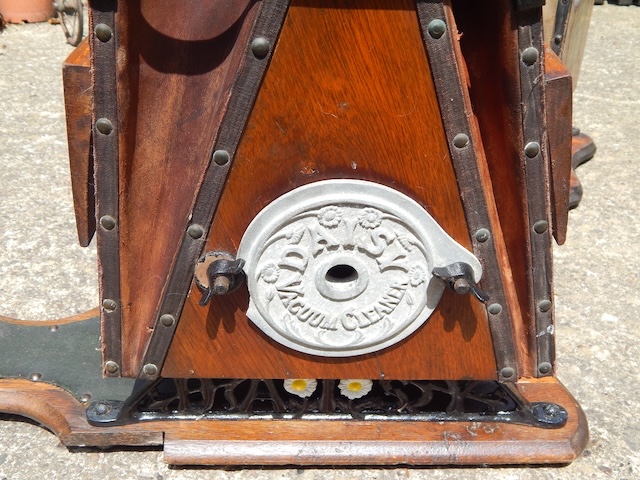 Detailed view of the side mechanics showcasing the lever and the embossed decorative plate reading "Vacuum Cleaner," offering a peek into the craftsmanship and artistic touch of the era