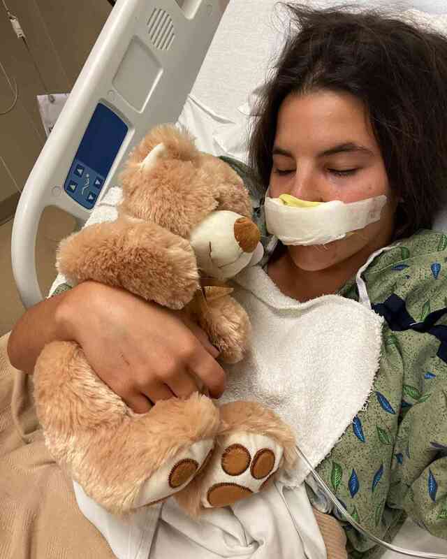 Brooklinn resting after surgery, finding comfort in a teddy bear—a reminder of her incredible fight and recovery.