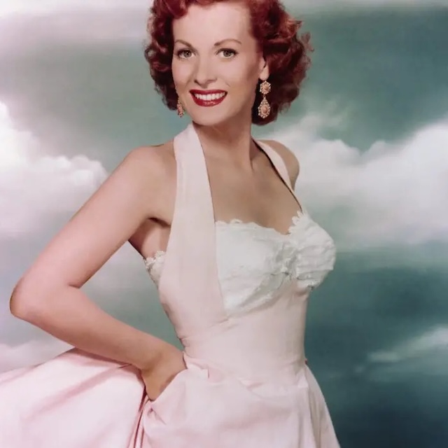  A classic photo of Maureen O'Hara in a breathtaking pastel dress, capturing her charm and glamour in full force. Known for her roles in iconic films, she effortlessly embodied sophistication and strength