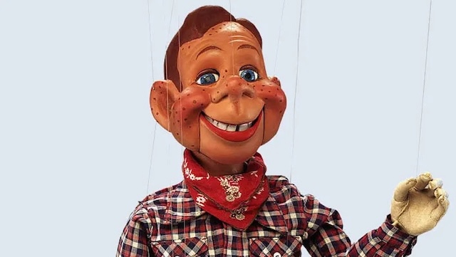 A close-up of Howdy Doody’s cheerful face, showcasing his signature freckles and iconic plaid outfit, symbolizing childhood joy for millions of viewers