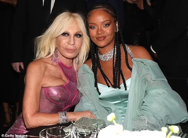 Donatella shares a moment with singer Rihanna at a high-profile fashion event, both radiating confidence and beauty in their respective glamorous outfits