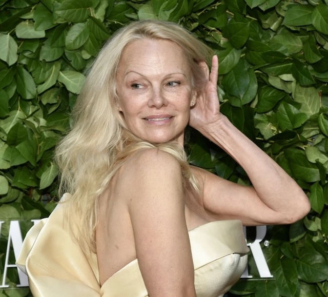 Pamela Anderson embracing her natural beauty at a glamorous red carpet event, showcasing confidence in her bare face and effortless style