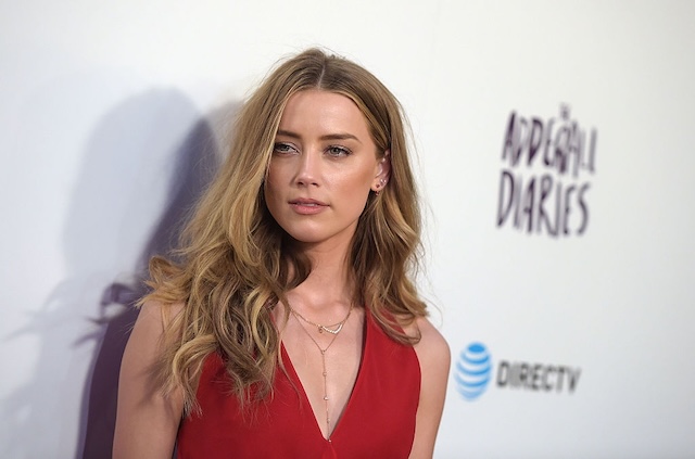 Amber Heard steps out in a bold red dress, effortlessly captivating the crowd with her radiant beauty at a movie premiere