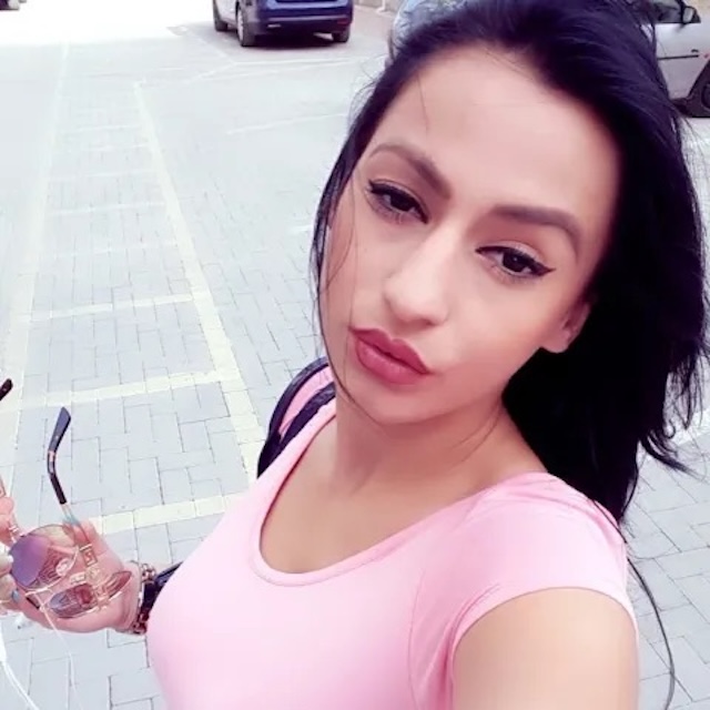 Enki poses casually outside in a pink top, showing off her natural beauty and effortless style, further cementing her place as a rising media personality