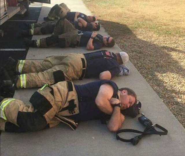 Firefighters taking a break after an intense 24-hour shift, exhausted from their heroic efforts