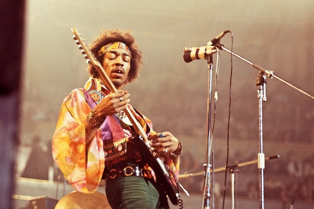 Jimi Hendrix in action on stage, electrifying the audience with his signature guitar style and dynamic performance during his prime.