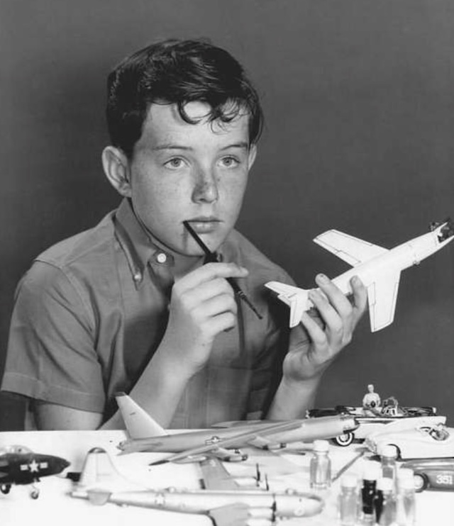 A young Beaver Cleaver, played by Jerry Mathers, engrossed in painting model planes. This nostalgic image captures the innocence and curiosity of the character, beloved by fans of the classic sitcom