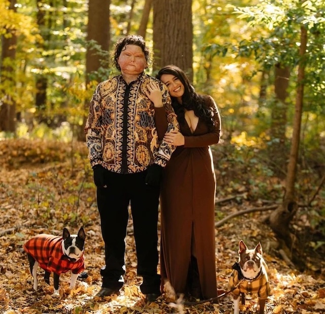 A picture of Joe and his partner posing for a portrait with their dogs in the beautiful autumnal woods, enjoying life after his remarkable recovery