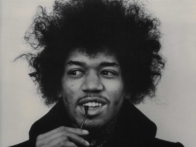 A memorable black and white image of Jimi Hendrix during his later years, with his distinctive wild hair and intense gaze, symbolizing his lasting influence on rock music