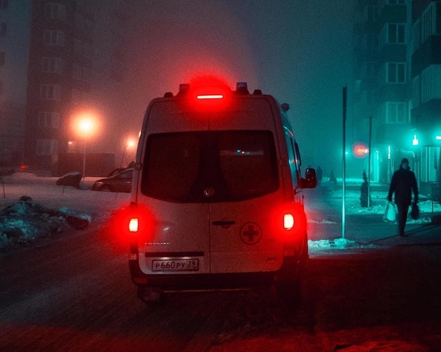 An ambulance driving through a nighttime urban setting, symbolizing the emergency response that could have saved a life after taking ChatGPT's advice seriously