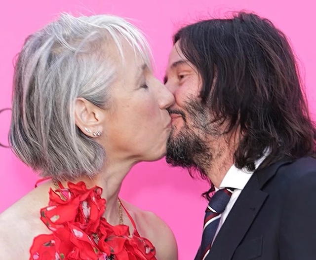 Keanu Reeves and Alexandra Grant embrace affectionately during a red carpet event, radiating warmth and love.