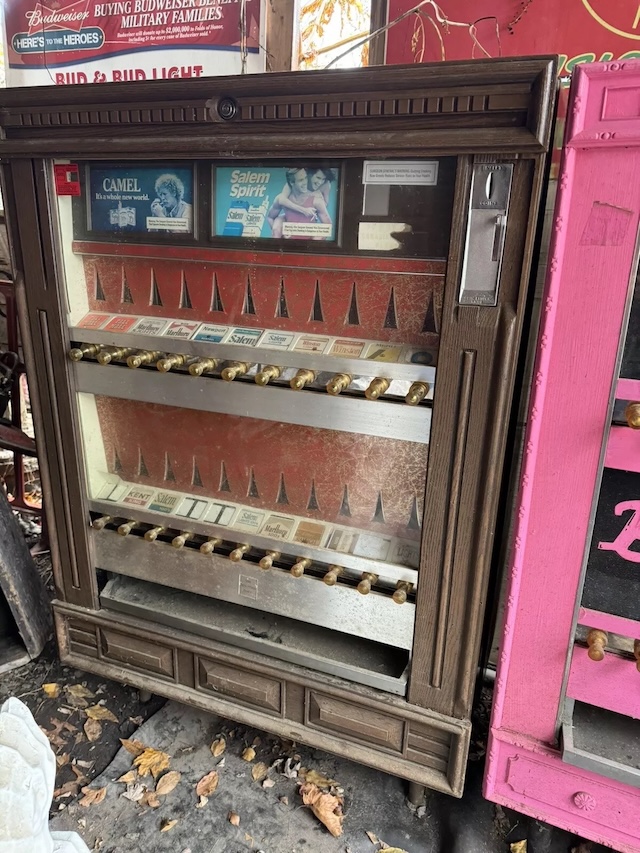 A closer look at a vintage cigarette vending machine with its iconic knobs and detailed labels, once a fixture in bars, diners, and bowling alleys