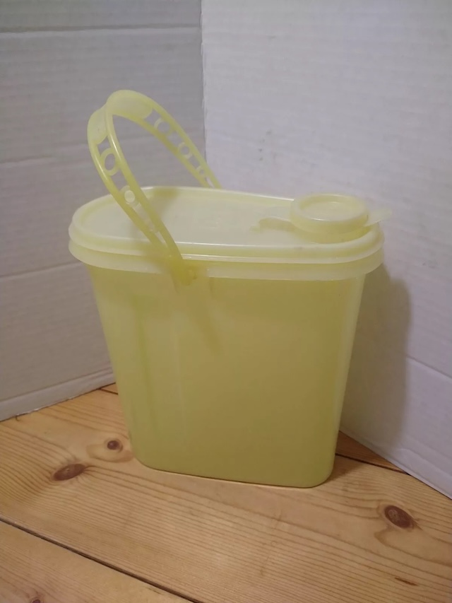 With its cheerful yellow hue and iconic sturdy handle, this vintage 1970 Tupperware carrier stood the test of time, perfect for family picnics and outdoor gatherings