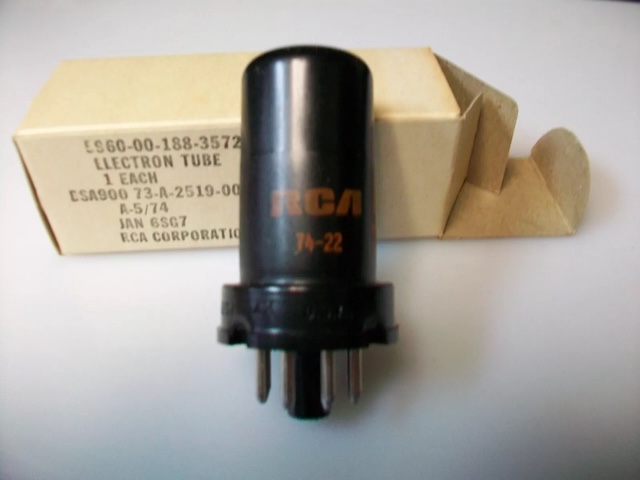 A black RCA Electron Tube from the 1970s in a minimalist cardboard box, showcasing its practical design for military and civilian use