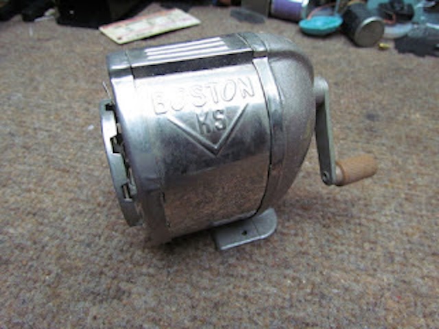 A side view of the Boston Model KS Pencil Sharpener, highlighting its robust metal casing and crank handle