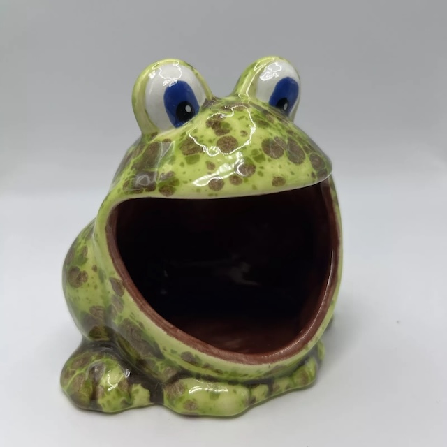 A vintage ceramic sponge holder with green and brown patterns, showcasing its timeless, whimsical frog-inspired design