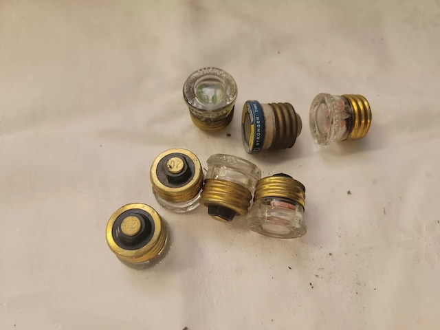 A set of vintage glass fuses spread out, highlighting their unique craftsmanship and utility in providing circuit protection